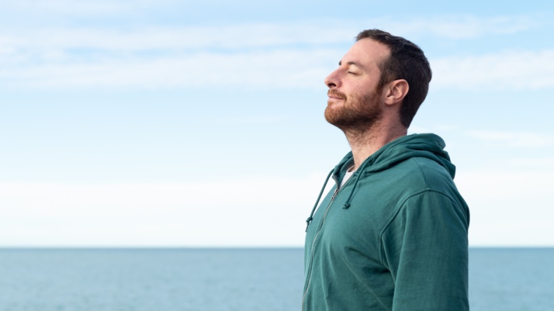 man-breathing-in-next-to-seaside